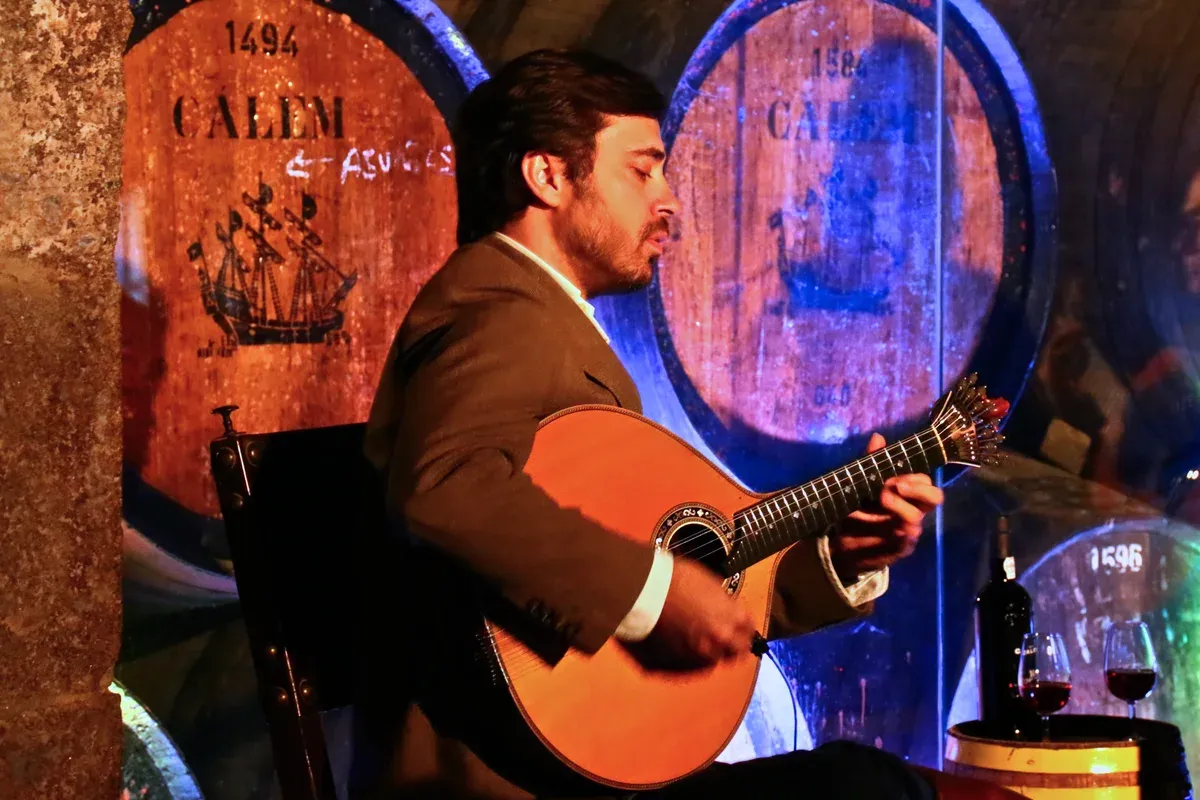 A Portuguese guitar player at a fado show in the Cálem cellars, seen on a port wine cellar tour in Vila Nova de Gaia