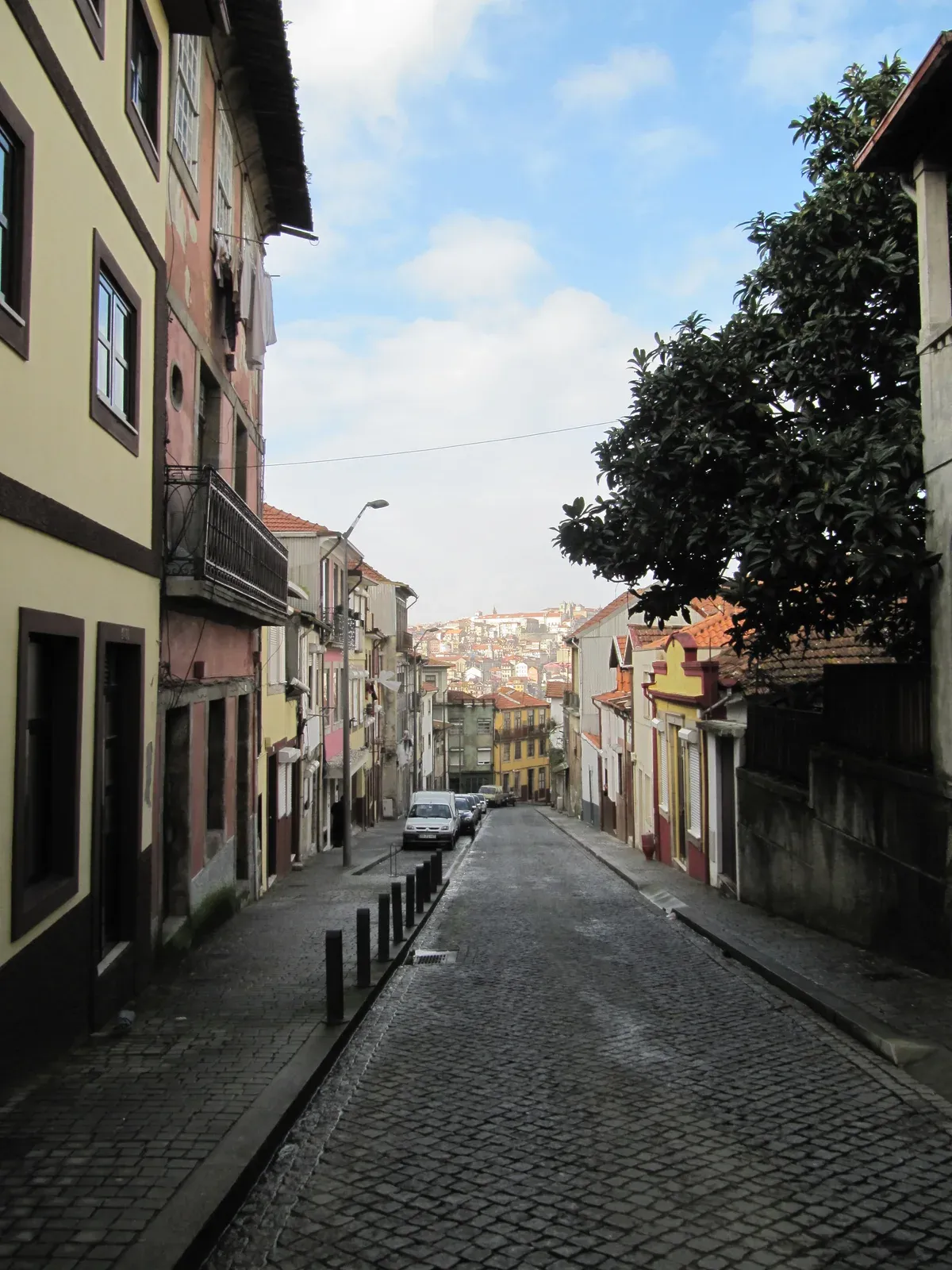 A cobbled lane in Vila Nova de Gaia with Porto beyond, seen on a port wine cellar tour in Vila Nova de Gaia