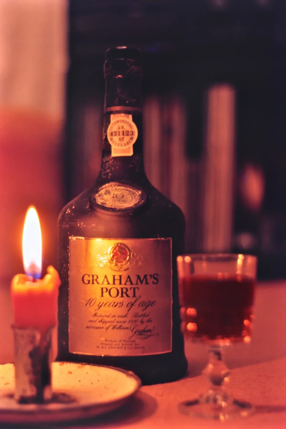 A bottle of Graham's port by candlelight in a still life, seen on a port wine cellar tour in Vila Nova de Gaia