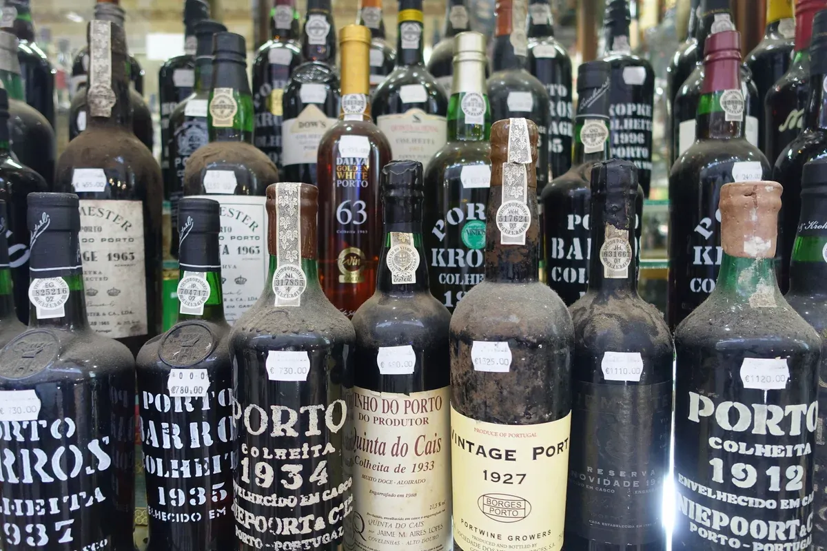 Bottles of colheita and vintage port on a shop shelf, seen on a port wine cellar tour in Vila Nova de Gaia