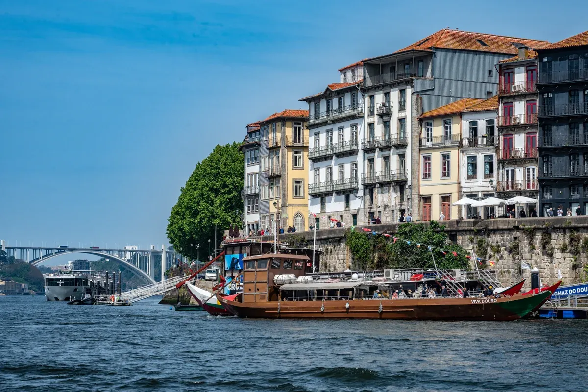 A rabelo cruise boat passing the Ribeira houses on the Douro, seen on a port wine cellar tour in Vila Nova de Gaia